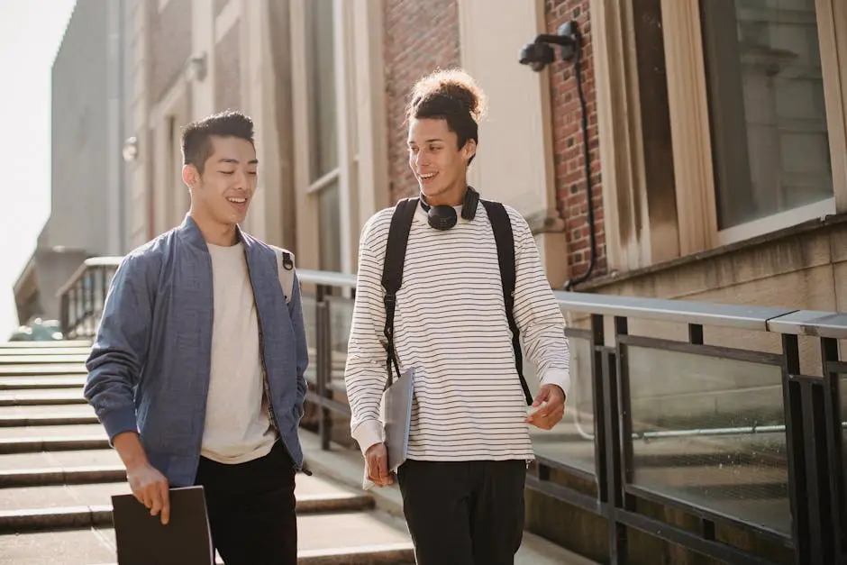 Two young men walking and smiling together on a sunny university campus