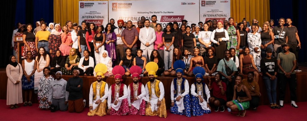A large group photo of international students at Chandigarh University during their orientation event, showcasing cultural diversity and community spirit.